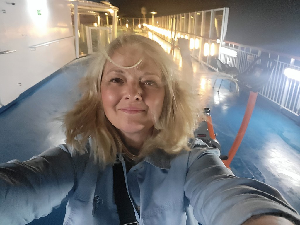 A windswept, happy selfie taken on deck of the ferry to Spain